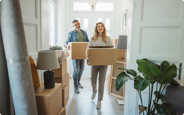 Couple moving boxes into House
