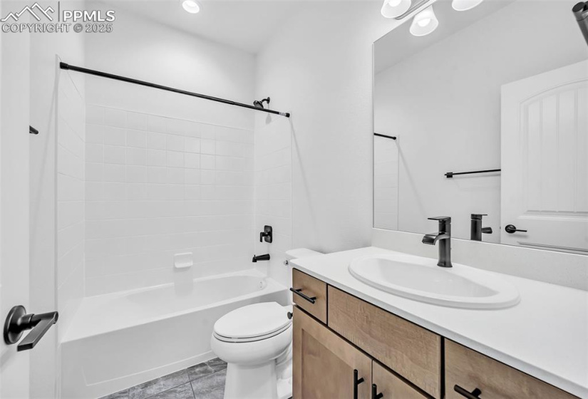 Bathroom with toilet, vanity, shower / bath combination, and tile patterned flooring