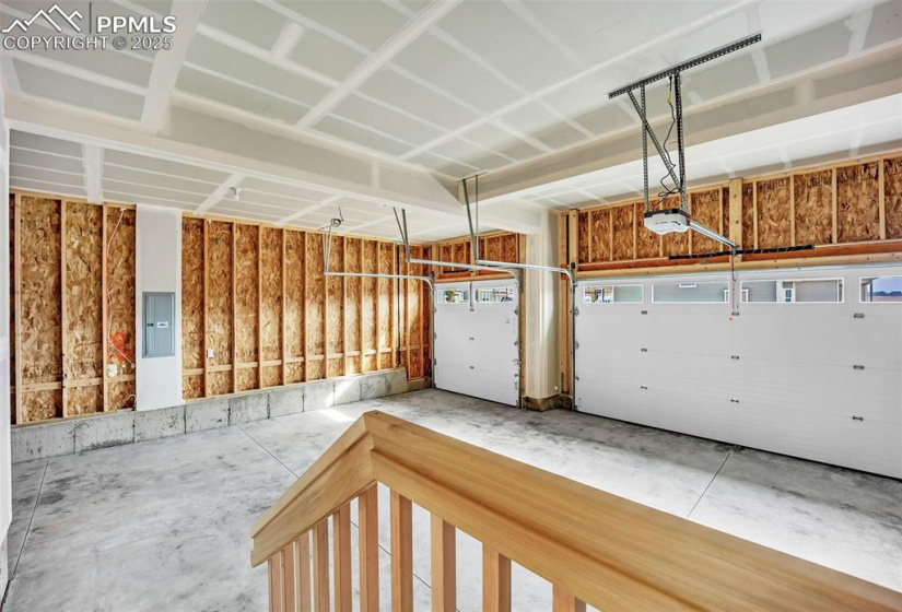 Garage featuring electric panel and a garage door opener