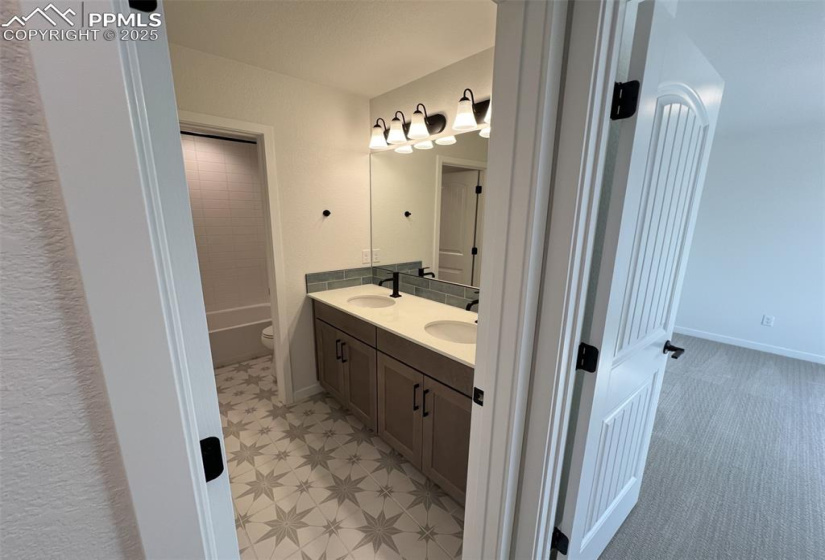 Full bathroom featuring double vanity and shower / tub combination