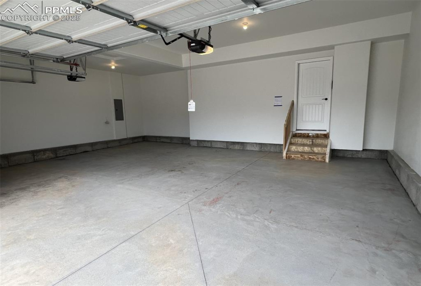 Garage featuring electric panel and a garage door opener