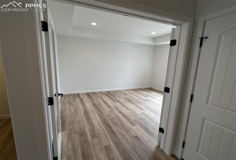 Study featuring light wood-type flooring and recessed lighting