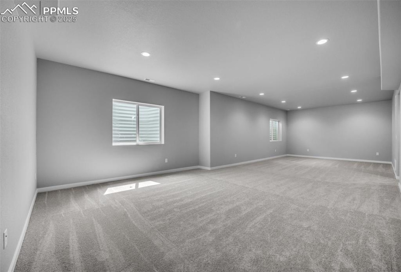 Carpeted empty room with recessed lighting and baseboards